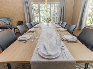 a long table with plates and glasses on it at Holiday Home Villa kallahti beach view helsinki by Interhome in Helsinki
