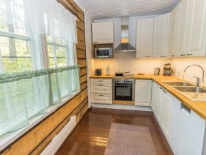 a kitchen with white cabinets and a large window at Holiday Home Villa kallahti beach view helsinki by Interhome in Helsinki +17 photos
