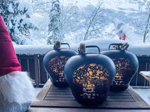 four black vases sitting on a table in the snow at Holiday Home Chalet Tannengüetli by Interhome in Grindelwald