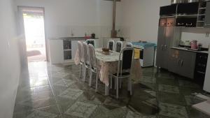 a kitchen with a table and chairs in a kitchen at Aluguel por temporada in Mucugê +3 photos