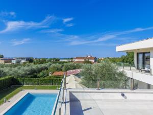 Una vista de una piscina desde una casa. en Villa Bianca by Interhome, en Bužinija