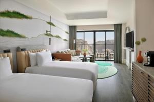 a hotel room with two beds and a living room at Hotel Indigo Jabal Akhdar Resort & Spa by IHG in Al ‘Aqar