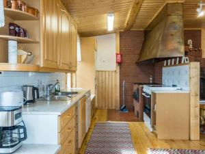 a kitchen with white appliances and wooden cabinets at Holiday Home Ounasmosku by Interhome in Tepasto