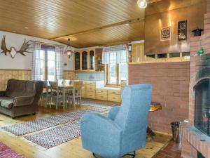 a living room with a blue chair and a brick fireplace at Holiday Home Ounasmosku by Interhome in Tepasto