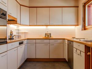 a kitchen with white cabinets and white appliances at Holiday Home Chalet Mirabelle by Interhome in Nendaz