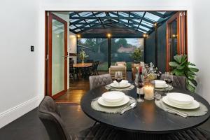 a dining room with a black table and chairs at Essex Cottage with garden, 2BR, near Adelaide Showground in Wayville