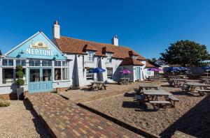 a restaurant with picnic tables in front of a building at Tucker’s Retreat in Dymchurch