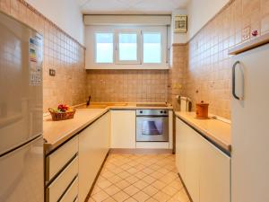 a small kitchen with white cabinets and a window at Apartment SunnyLake by Interhome in Riva del Garda