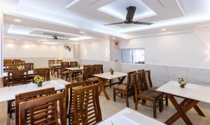 a restaurant with tables and chairs and a ceiling at Treebo Premium Cochin Airport, 5 min From Cochin Airport in Cochin