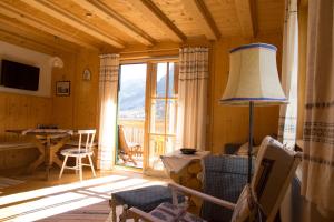 ein Wohnzimmer mit einem großen Fenster und einem Tisch in der Unterkunft Haus Paradies am See in Grundlsee