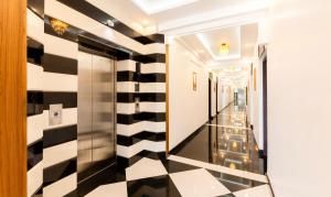 a hallway with a black and white checkered floor at Treebo Premium Cochin Airport, 5 min From Cochin Airport in Cochin