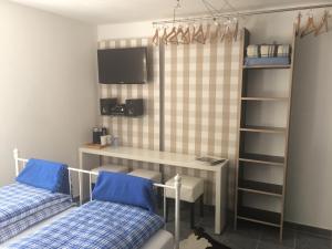 a room with two beds and a desk and a tv at Chiemgau-ROOM, helles Souterrain, eigene Terrasse in Riedering