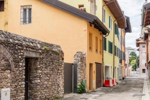 eine Gasse mit einer Steinmauer und einem Gebäude in der Unterkunft Terratetto in centro con parcheggio in Udine