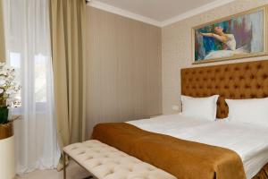 a bedroom with a bed and a painting on the wall at Villa Maria in Balchik