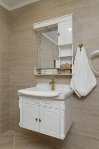 a white bathroom with a sink and a mirror at Villa Maria in Balchik