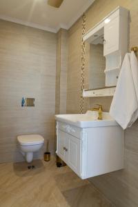 a bathroom with a white sink and a toilet at Villa Maria in Balchik +26 photos