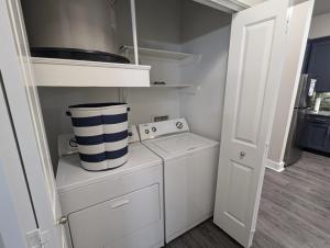 a small white kitchen with a washer and dryer at The Apollo - Lux 1-Bed Apartment near Space Center in Houston +12 photos