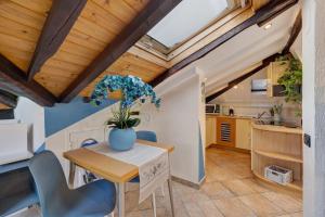 a kitchen and dining room with wooden ceilings at Mansarda Sotto Le Stelle in Savona