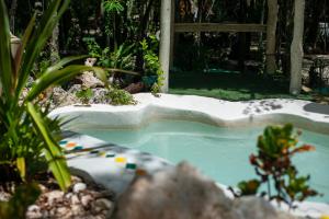 a hot tub in a garden with plants at Lovely Villa 1-BR Villa Miguel in Chemuyil
