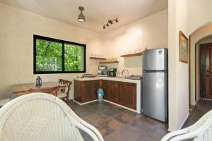a kitchen with a stainless steel refrigerator and a table at Lovely Villa 1-BR Villa Miguel in Chemuyil