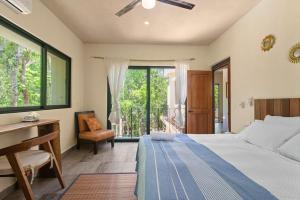 a bedroom with a bed and a desk and a window at Lovely Villa 1-BR Villa Miguel in Chemuyil