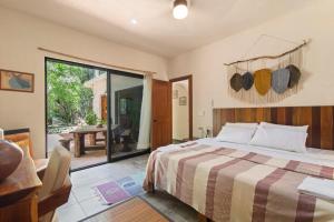 a bedroom with a bed and a sliding glass door at Lovely Villa 1-BR Villa Miguel in Chemuyil