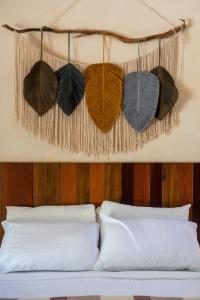 a bed with pillows and hats hanging on a wall at Lovely Villa 1-BR Villa Miguel in Chemuyil