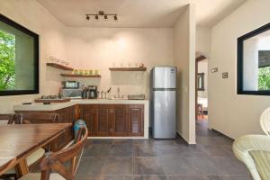 a kitchen with a refrigerator and a wooden table at Lovely Villa 1-BR Villa Miguel in Chemuyil