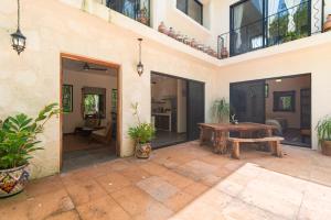 an outdoor patio with a wooden table and a bench at Lovely Villa 1-BR Villa Miguel in Chemuyil