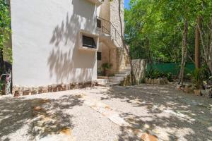 a building with a shadow of a tree on the side of it at Lovely Villa 1-BR Villa Miguel in Chemuyil