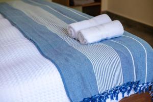 two rolled up towels on a blue and white bed at Lovely Villa 1-BR Villa Miguel in Chemuyil