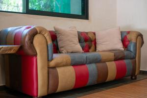 a couch with colorful pillows on it in a room at Lovely Villa 1-BR Villa Miguel in Chemuyil