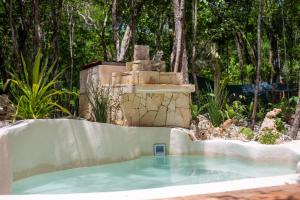 a swimming pool with a fountain in a garden at Lovely Villa 1-BR Villa Miguel in Chemuyil