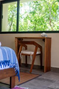 a bedroom with a desk and a chair under a window at Lovely Villa 1-BR Villa Miguel in Chemuyil