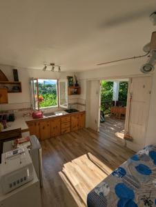 cocina con suelo de madera y cocina con ventanas en Home Song, en Calibishie
