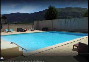 a large blue swimming pool with mountains in the background at T2 Cabine 4 à 6 pers Vue Montagne et Piscine in Vignec +12 photos