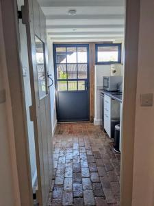a hallway with a door and a kitchen with a counter at No1 The yard, Regilbury Court, Winford in Bristol