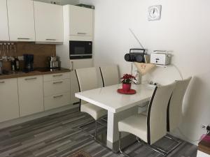 a kitchen with a white table and chairs at Moderne Ferienwohnung am Wald in Siegsdorf