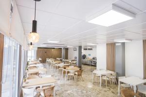 a restaurant with tables and chairs in a room at Alda Cabanas Playa in Cabañas