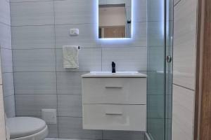 a bathroom with a toilet and a sink and a mirror at Golf Center - Urb El Golf Trujillo in Víctor Larco Herrera