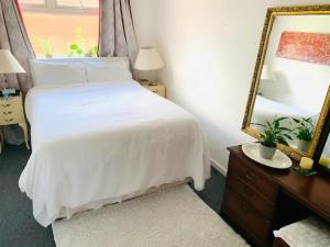 a bedroom with a white bed and a mirror at Bramley Fall Park Homestay in Horsforth +6 photos