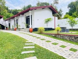 a walkway in front of a white building at Thara Inn Villa in Dickwella