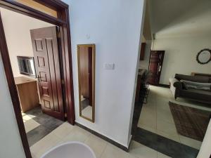 a hallway with a mirror and a living room at The Arches Accola in Nairobi +25 photos