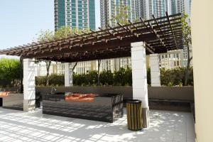 a wooden pergola with a trash can under it at Delmon دلمون in Abu Dhabi
