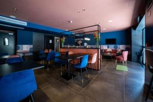 a restaurant with a table and chairs and a bar at Eleven by Warren Collection in Sliema