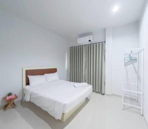 Ban Na PhoにあるNamthip Houseのベッドと窓のある白い寝室