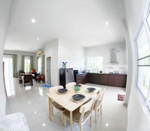 Ban Na PhoにあるNamthip Houseのテーブルと椅子のあるキッチンとリビングルーム
