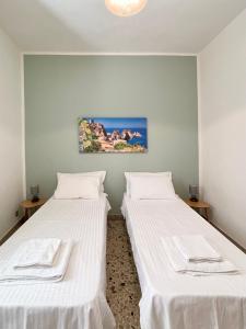 two beds in a room with white sheets at ViLoKa Sicilian Guest House in Calatafimi