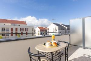 a table with a plate of food on a balcony at Cosy Melun 25 min Gare de Lyon in Melun