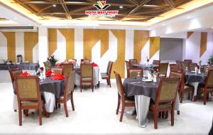a dining room with tables and chairs and a sign at Hotel West Valley - Baridhara in Dhaka